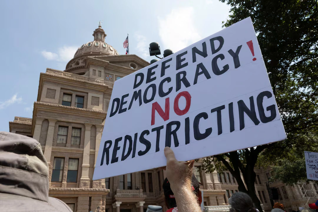 A protester raises a sign during one of the Fight the Trump Takeover nationwide rallies against Texas’ Republicans efforts to redraw the state's 38 congressional districts, at the State Capitol in Austin, Texas, U.S. August 16, 2025